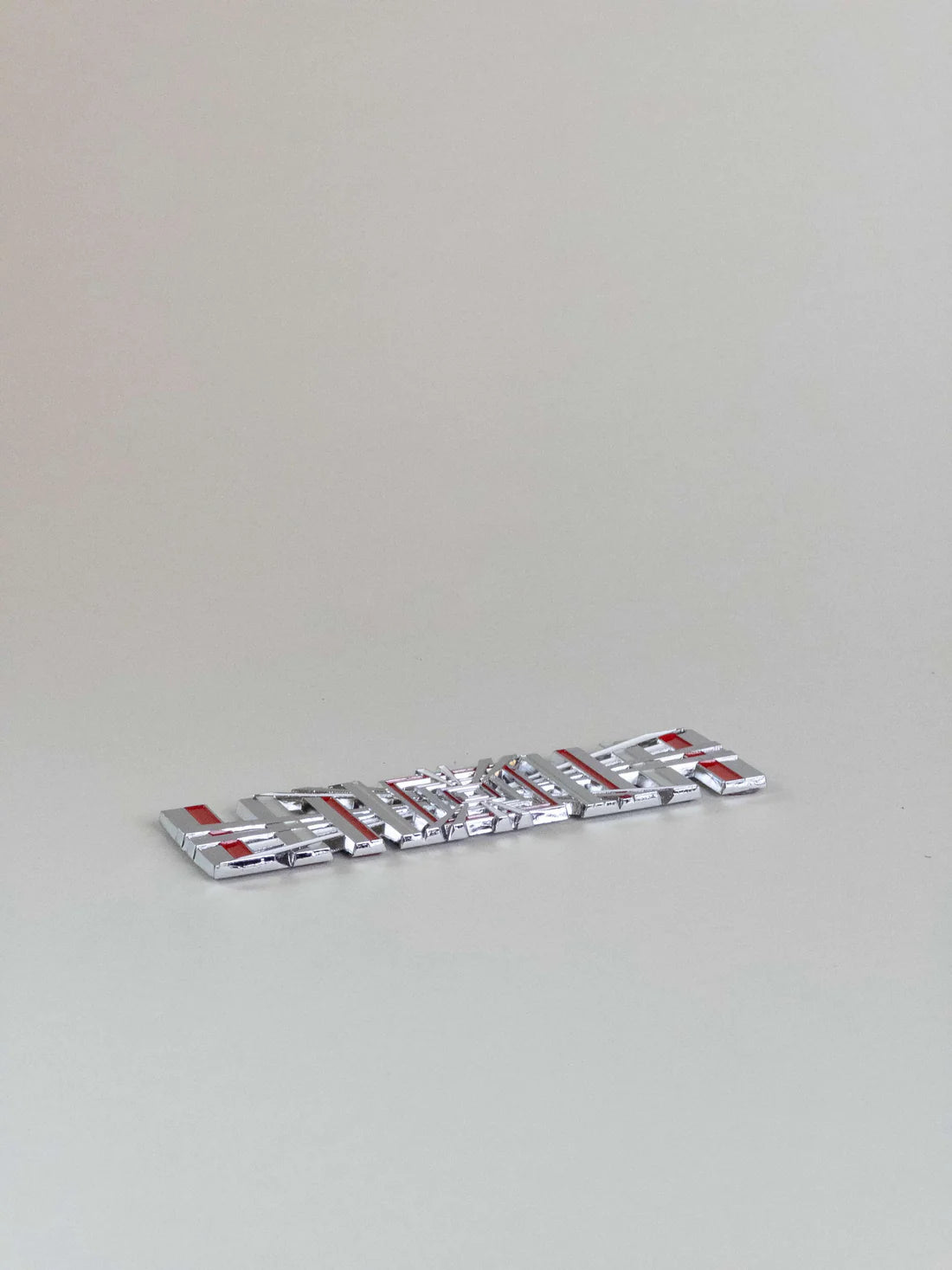 nærbillede af detaljer og materialer af Tesla Plaid Emblem/Badge Silver - TESLA
