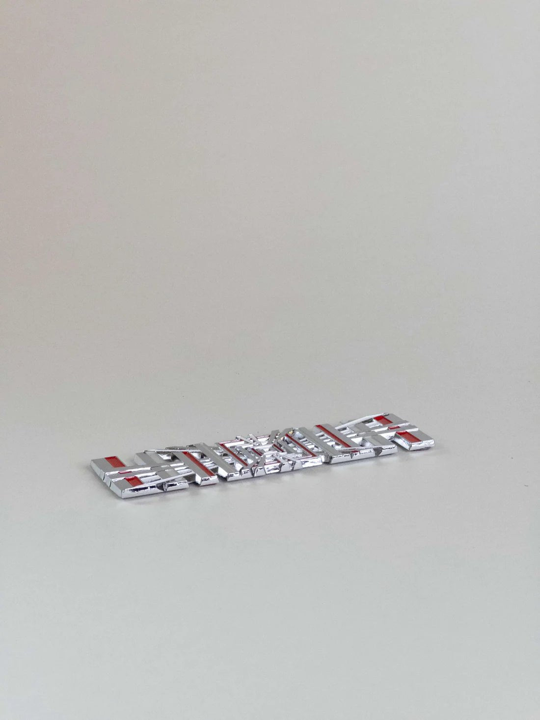 nærbillede af detaljer og materialer af Tesla Plaid Emblem/Badge Silver - TESLA