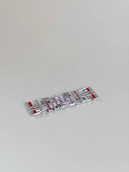 sidebillede, der viser profil og design af Tesla Plaid Emblem/Badge Silver - TESLA